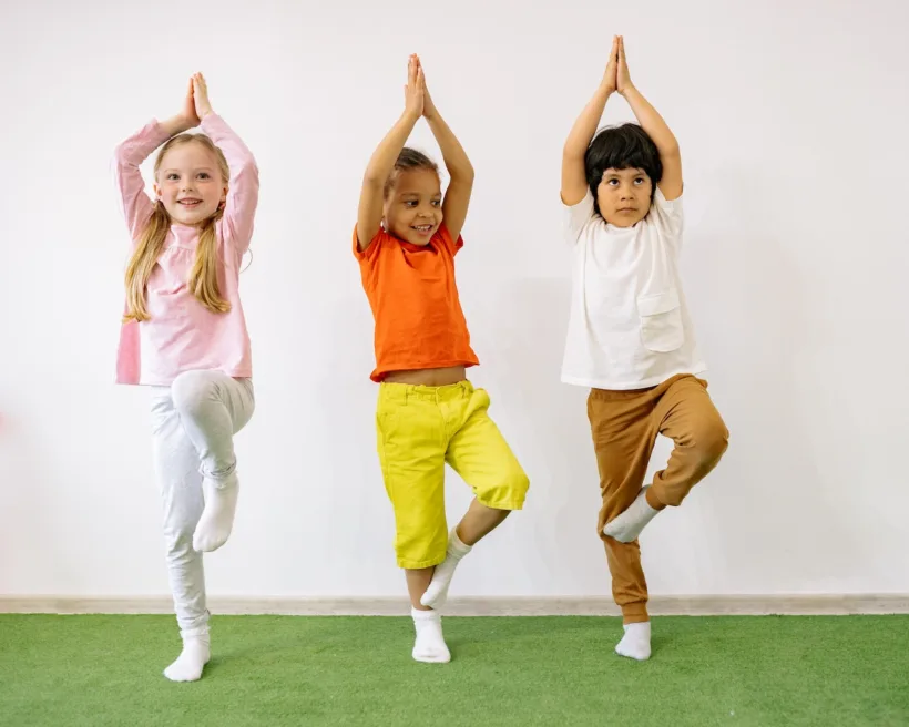 three kids doing yoga showing the benefits of staying active