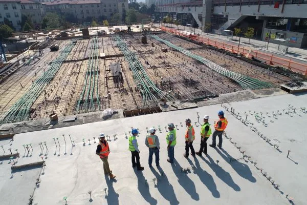 Men standing on a construction site surveying their work.