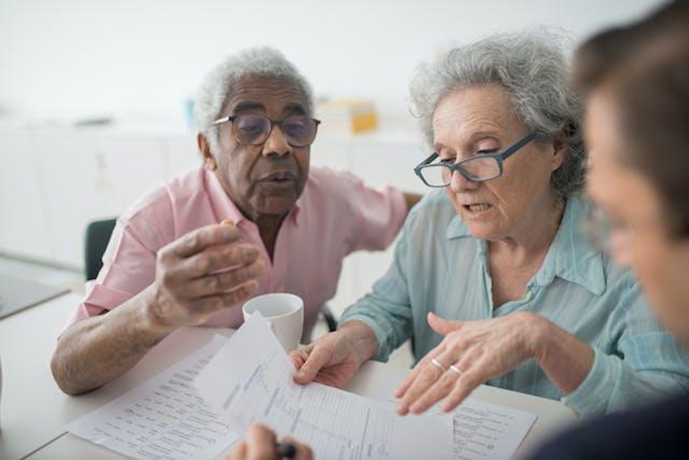 An elderly couple is reviewing documents
