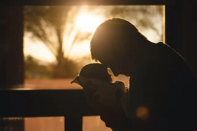 Man leaning in and touching his baby's head to head.